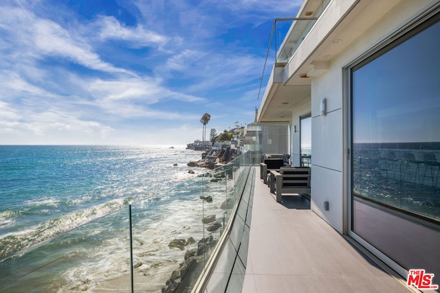 balcony with a water view and a beach view