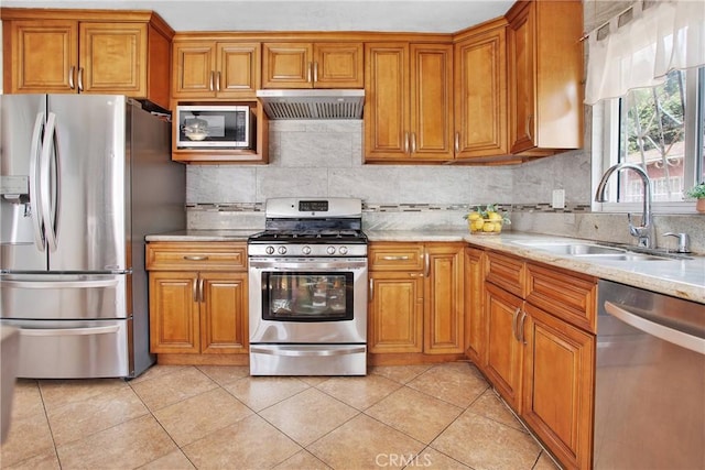 kitchen with light stone countertops, sink, light tile patterned flooring, and appliances with stainless steel finishes