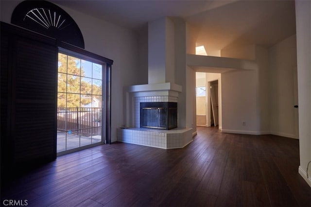 unfurnished living room with dark wood-type flooring and a fireplace