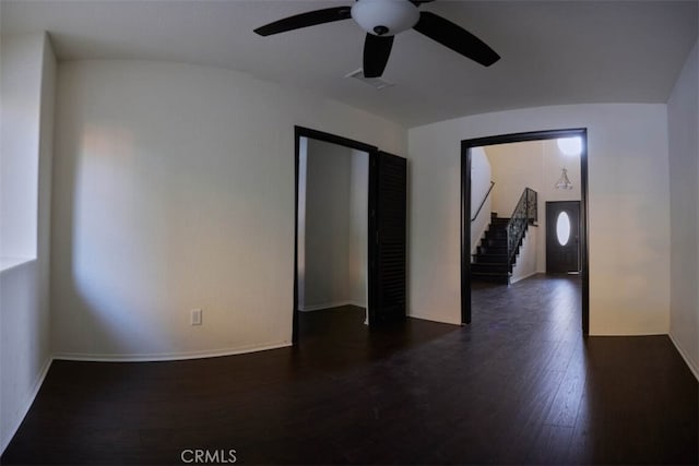 empty room with ceiling fan and dark hardwood / wood-style floors