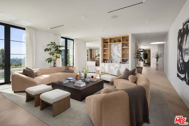 living room with floor to ceiling windows and light hardwood / wood-style flooring