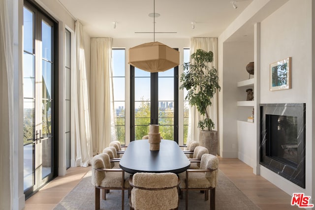 dining space with a premium fireplace and light hardwood / wood-style floors