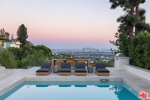 pool at dusk with a patio