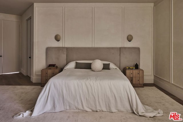 bedroom featuring multiple closets and dark hardwood / wood-style floors