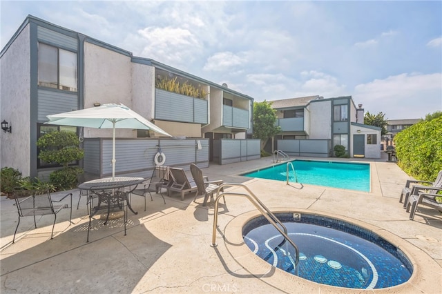 view of swimming pool with a community hot tub and a patio area