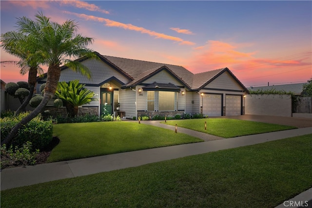 view of front of house with a garage and a yard