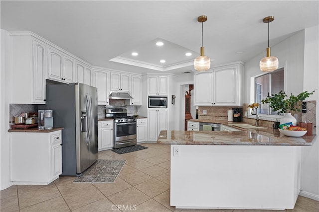 kitchen with white cabinets, kitchen peninsula, stainless steel appliances, decorative light fixtures, and sink