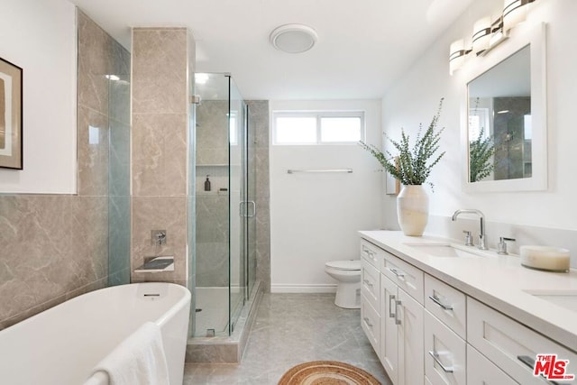 full bathroom featuring tile patterned floors, vanity, toilet, and independent shower and bath