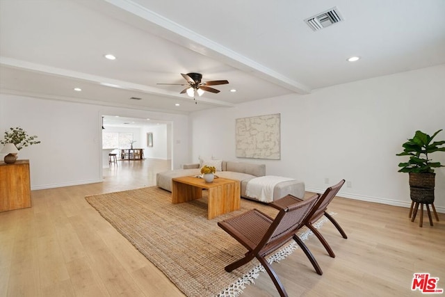 living room featuring beam ceiling, light hardwood / wood-style floors, and ceiling fan