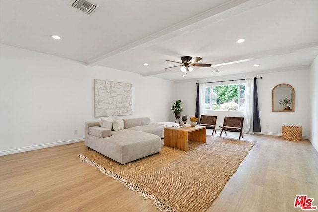 living room featuring beamed ceiling, light wood-type flooring, and ceiling fan