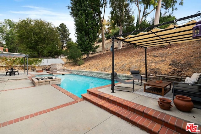 view of swimming pool featuring a patio, a pergola, and a fire pit