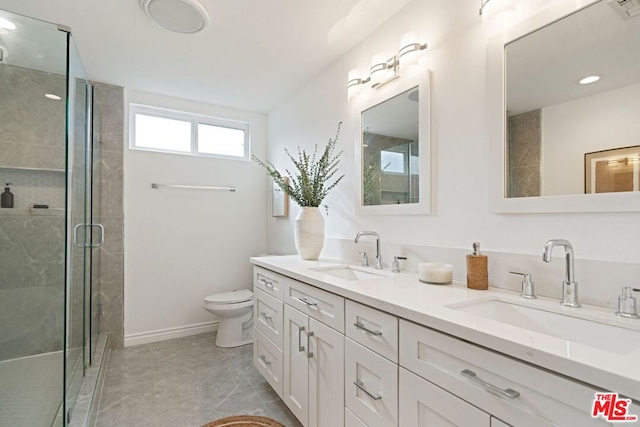 bathroom with vanity, toilet, and a shower with door