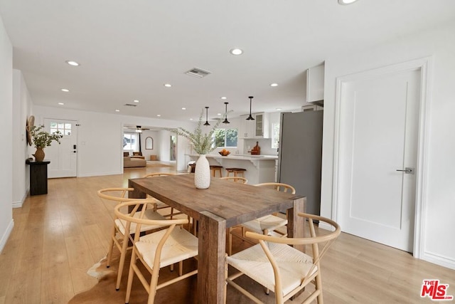 dining room with light hardwood / wood-style floors and ceiling fan