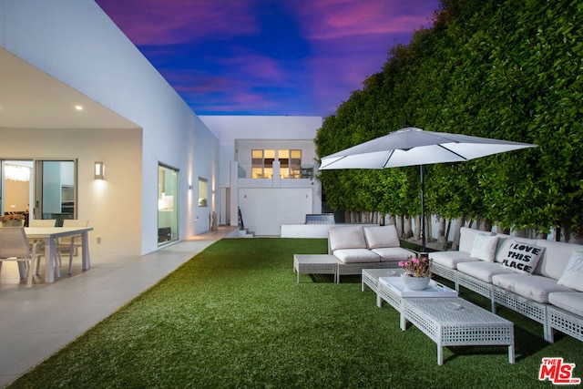 yard at dusk featuring outdoor lounge area and a patio area