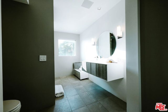 bathroom with tile patterned flooring, vanity, and toilet