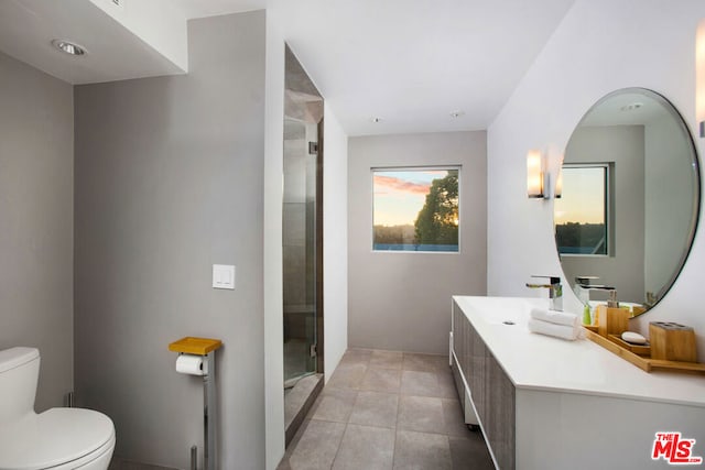 bathroom featuring tile patterned floors, vanity, toilet, and an enclosed shower