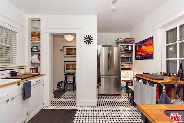 kitchen featuring white cabinetry, backsplash, and stainless steel appliances