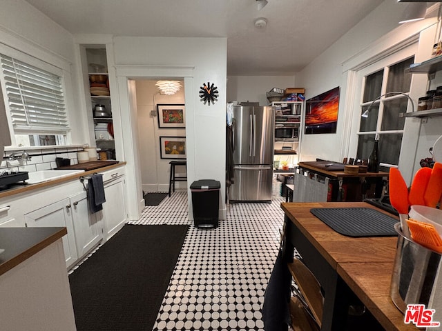 kitchen featuring white cabinetry, appliances with stainless steel finishes, and butcher block counters