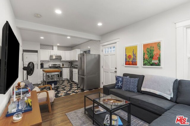 living room with beam ceiling and dark hardwood / wood-style flooring