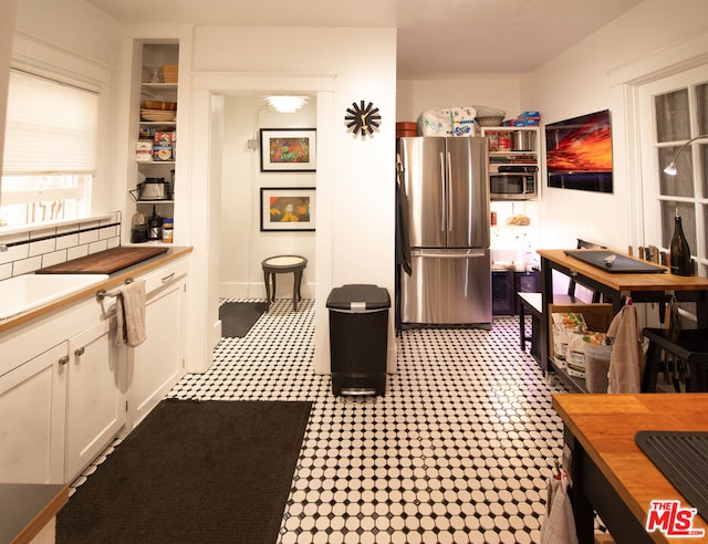 kitchen featuring appliances with stainless steel finishes, sink, decorative backsplash, and white cabinets