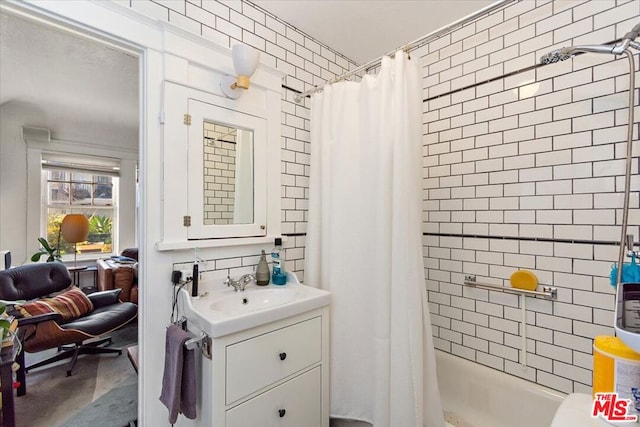 bathroom featuring vanity and shower / bathtub combination with curtain