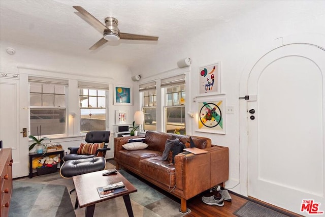 living room with dark hardwood / wood-style flooring and ceiling fan