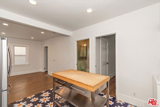 home office with dark wood-type flooring and beam ceiling