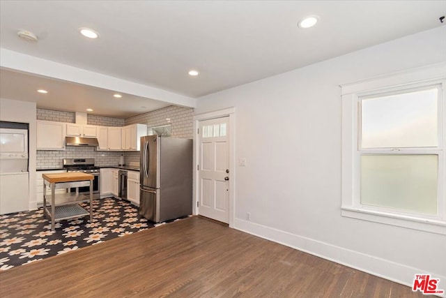 kitchen featuring dark wood-type flooring, appliances with stainless steel finishes, and tasteful backsplash