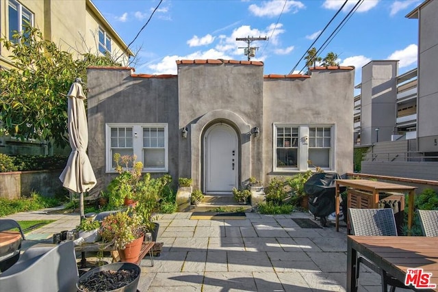 view of exterior entry featuring a patio area