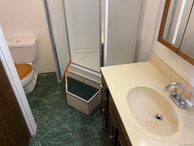 bathroom featuring vanity, toilet, and an enclosed shower