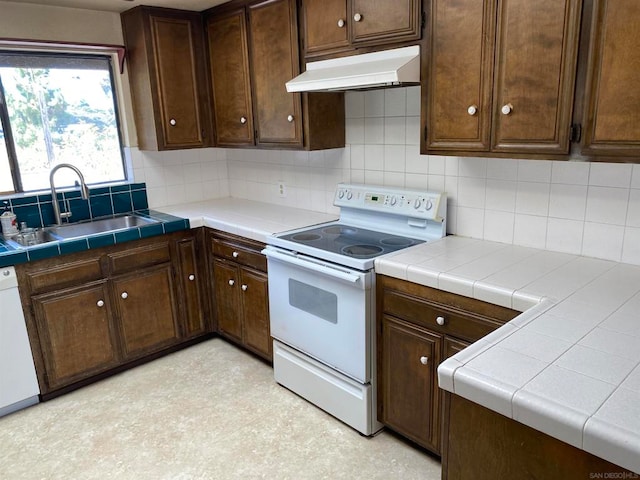 kitchen with tile countertops, dark brown cabinetry, sink, and white appliances