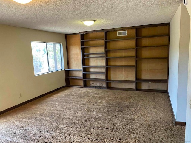 interior space with a textured ceiling and built in shelves