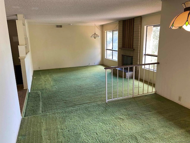 unfurnished living room with a textured ceiling, a fireplace, and carpet floors