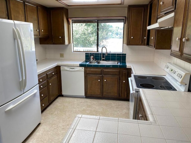 kitchen with white appliances, tile countertops, dark brown cabinets, and sink