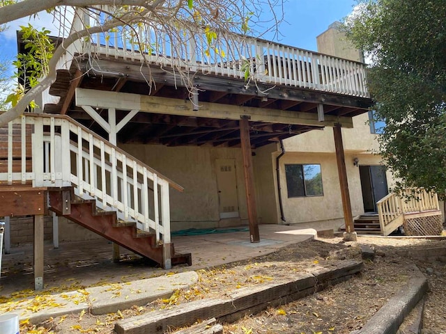 back of property featuring a wooden deck and a patio area