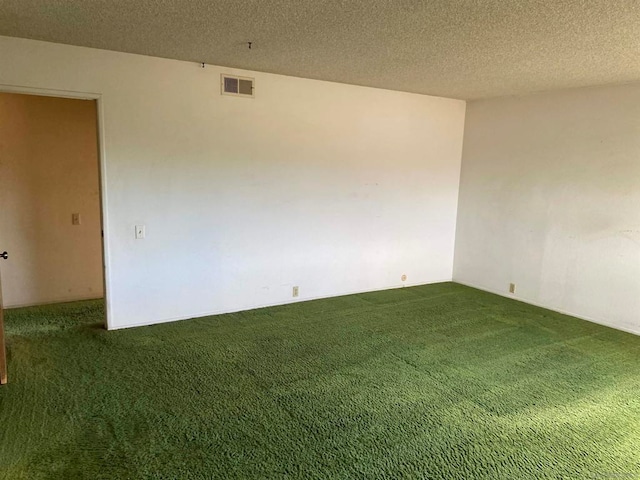 carpeted empty room featuring a textured ceiling