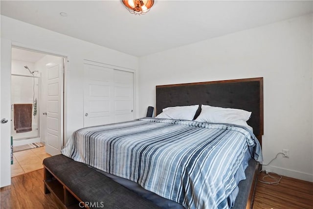 bedroom featuring hardwood / wood-style floors, ensuite bathroom, and a closet