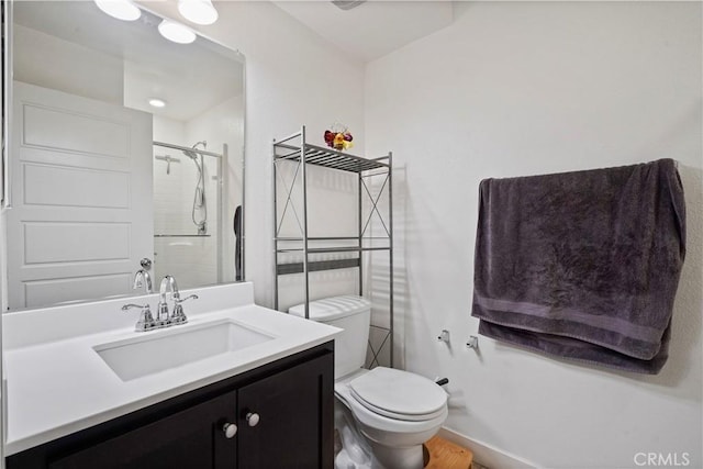 bathroom featuring an enclosed shower, vanity, and toilet