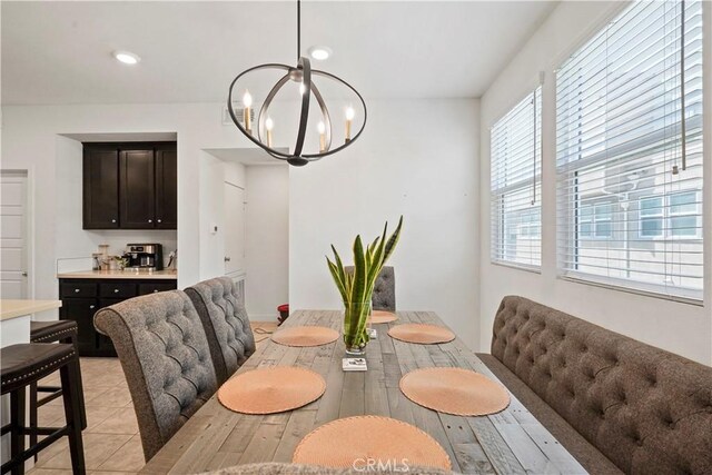 tiled dining area featuring a chandelier