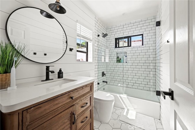 full bathroom with tiled shower / bath combo, vanity, and toilet