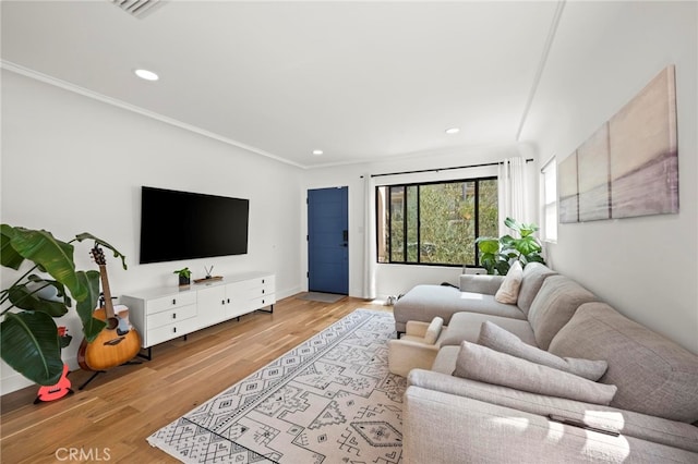 living room featuring light wood-type flooring and crown molding