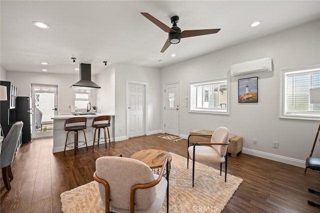 living room featuring dark hardwood / wood-style flooring, ceiling fan, a healthy amount of sunlight, and a wall mounted AC