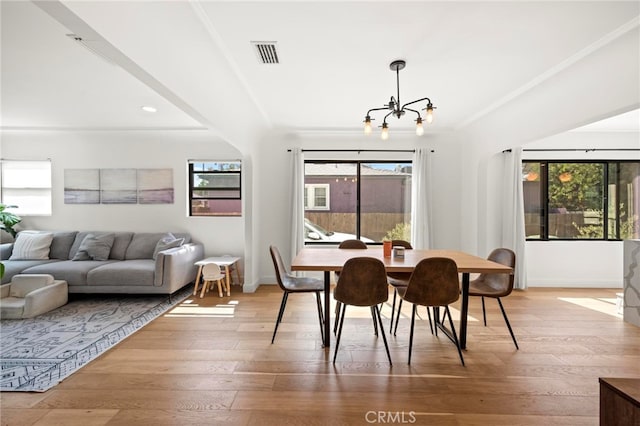 dining room featuring an inviting chandelier, hardwood / wood-style floors, and a healthy amount of sunlight