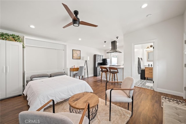 bedroom featuring ceiling fan, black refrigerator, ensuite bathroom, and dark wood-type flooring