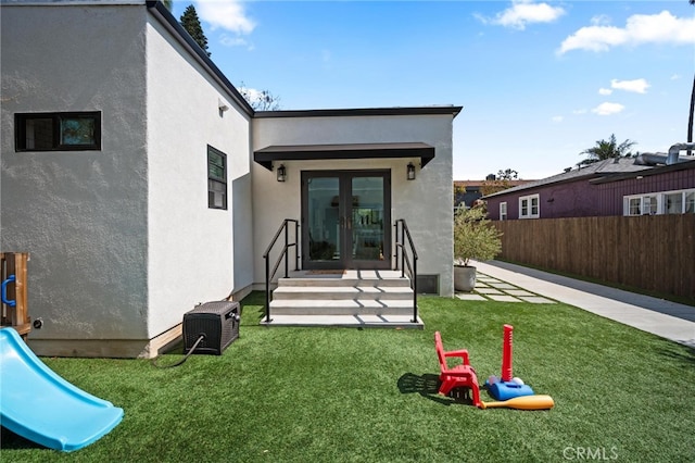 back of property with french doors and a yard