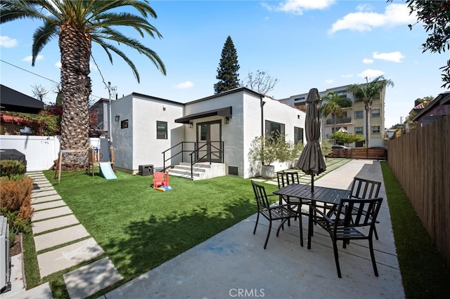 rear view of house with a patio and a yard