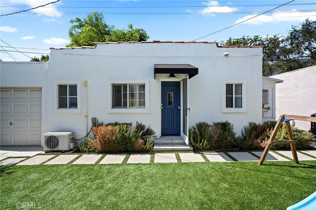 art deco inspired home featuring a front yard, a garage, and ac unit