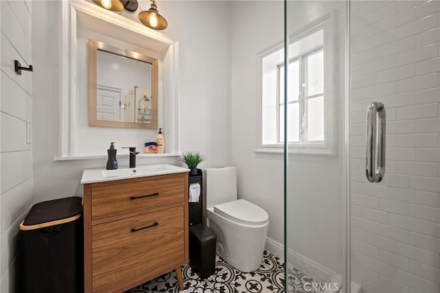 bathroom featuring vanity, tile patterned flooring, toilet, and a shower with door