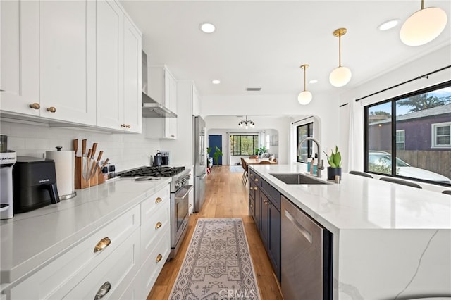 kitchen with pendant lighting, appliances with stainless steel finishes, plenty of natural light, and sink