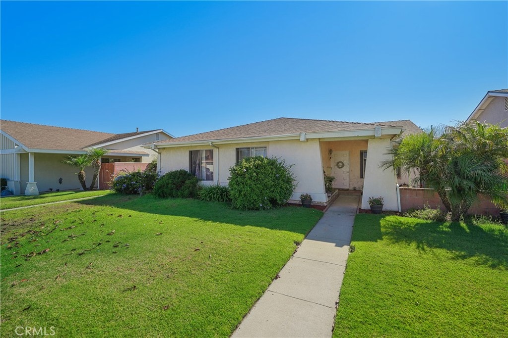 ranch-style house featuring a garage and a front lawn